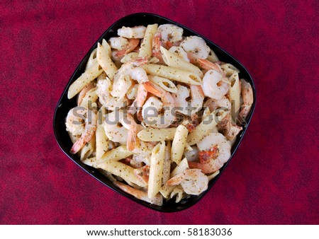 pesto shrimp pasta in a black bowl closeup photo