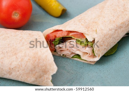 one cut turkey, tomato and lettuce wrap sandwich