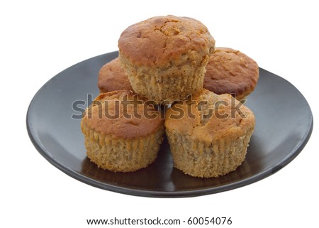 small stack of five banana muffins in yellow on a black plate over white