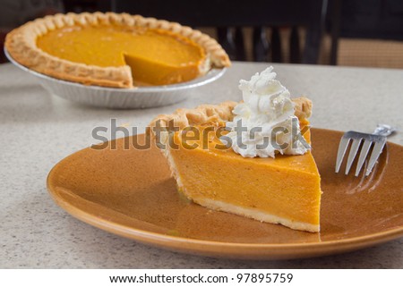 one slice of pumpkin  pie removed from the whole and ready to eat