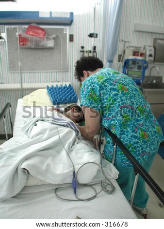 Nurse attends to a child after surgery.