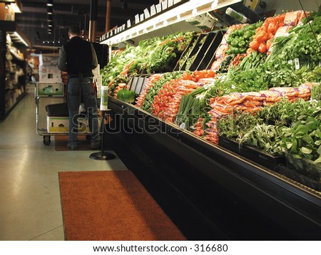 Clerk works in produce section of grocery store.