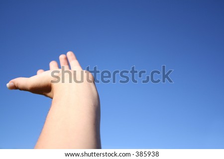 Woman holds hand out to the sky.