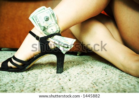 Woman;s legs with cash stuffed in shoe. Cross proccessed effect.