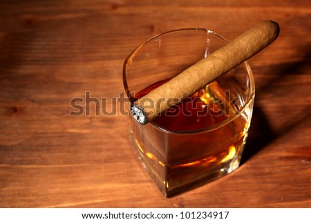 two glass of whiskey and cigar on wooden table