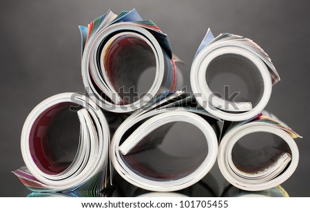 Rolled up magazines on gray background