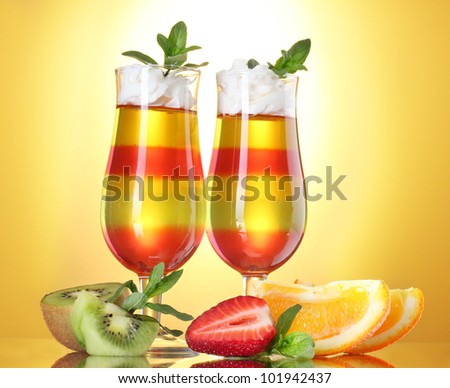 fruit jelly in glasses and fruits on yellow background