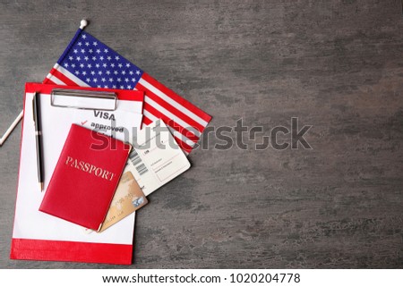 Passport, ticket, credit card and USA flag on table. Approved American visa