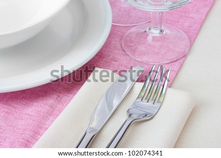 Table setting with fork, knife, plates and napkin