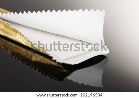 Chewing gum on the wrapping foil on gray background