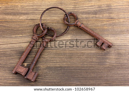 a bunch of antique keys on wooden background