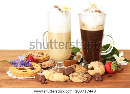 glasses of coffee cocktail on wooden table with sweet and flowers on white background