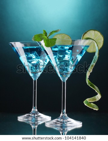 Blue cocktail in martini glasses on blue background