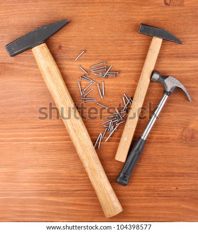 Hammers and metal nails on wooden background