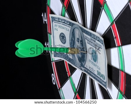 Dollar on bulls eye. Darts  close-up on black background