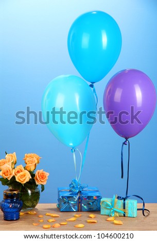 Romantic gift boyfriend. Colorful balloons holding a gifts on blue background
