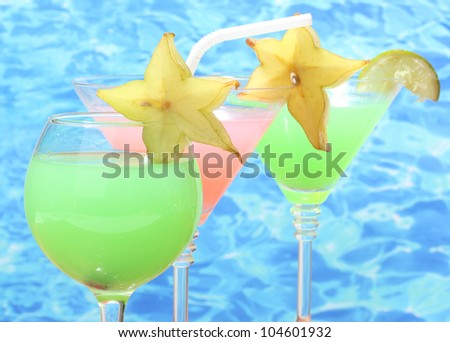 Glasses of cocktails on blue sea background