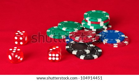 Poker chips wirh dice on a red table