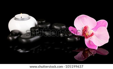 Spa stones with orchid flower and candle isolated on black