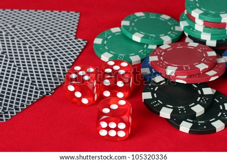 poker chips, dice and cards on a red table