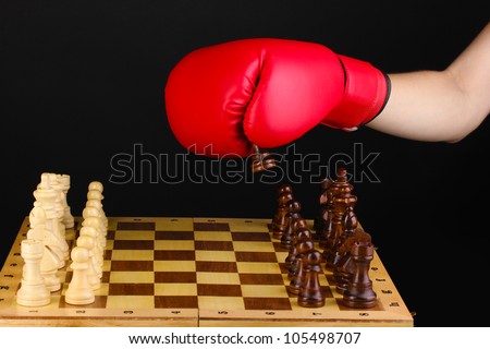 Playing chess in boxing gloves isolated on black