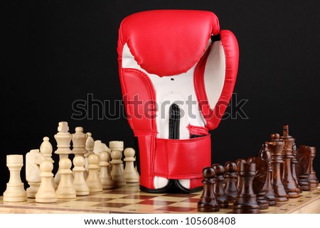 Chess board and boxing glove isolated on black