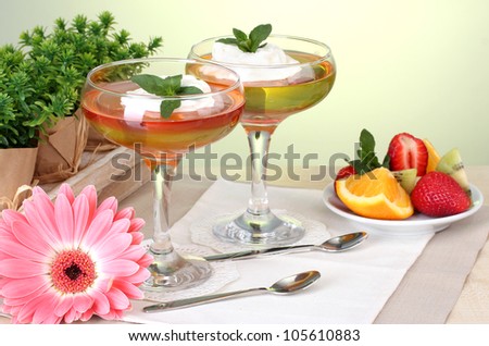 fruit jelly in glasses and fruits on table in cafe