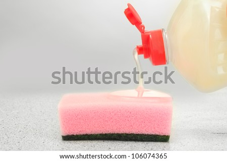 bright sponge with dish washing liquid on marble background