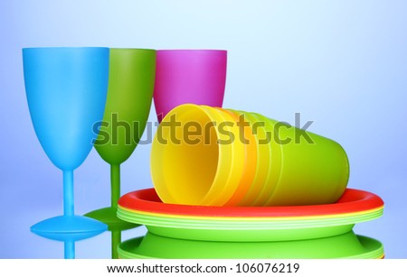 Bright plastic tableware on blue background