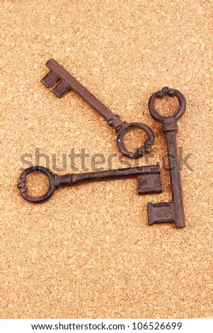 a bunch of antique keys on cork background