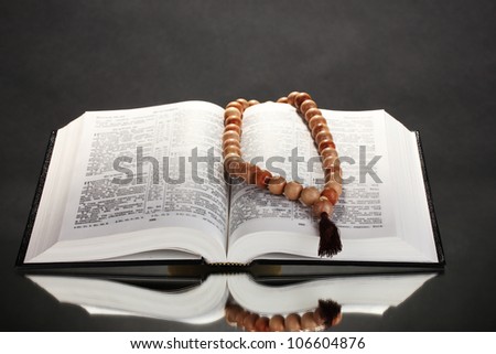 Russian open holy bible with wooden rosary on black backround Russian open holy bible with wooden rosary on black backround