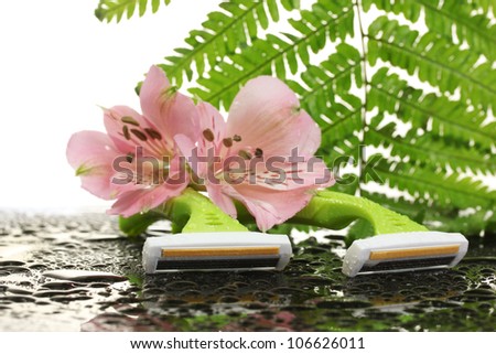 woman safety shavers with drops, leaf and flowers on grey backgroud