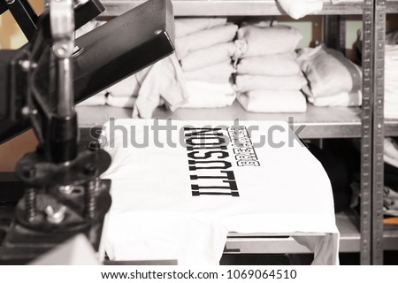 Modern printing machine with t-shirt at workplace