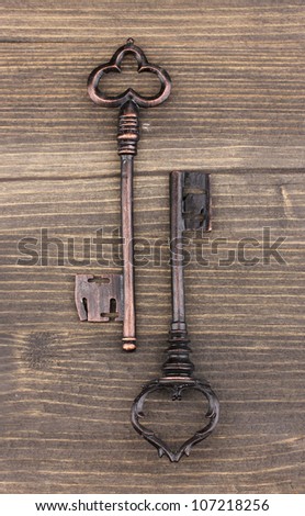Two antique keys on wooden background
