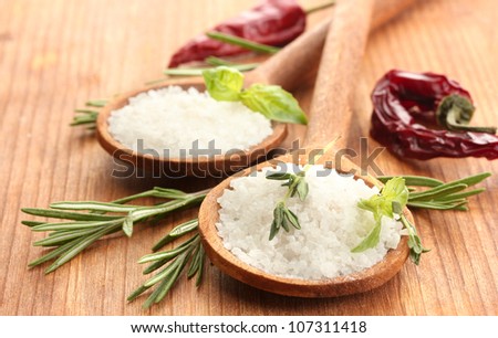 salt in spoons with herbs and vegetables isolated on white