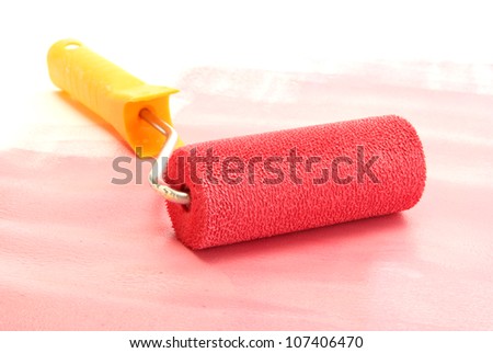 Paint roller with red paint close up