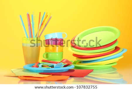 bright plastic disposable tableware on colorful background