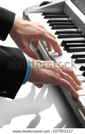 hands of man playing piano