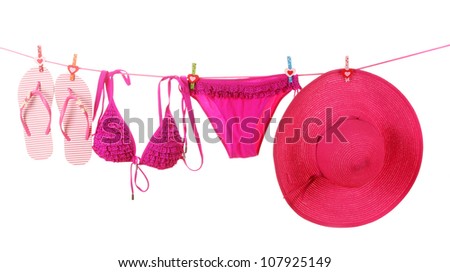 Women\'s swimsuit, hat and flip-flops hanging on a rope on white background