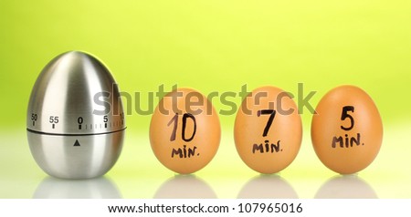 egg timer and eggs on green background