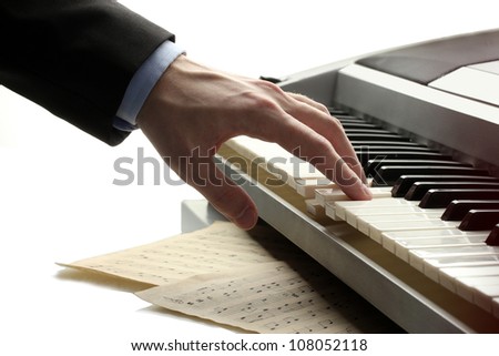 hand of man playing piano