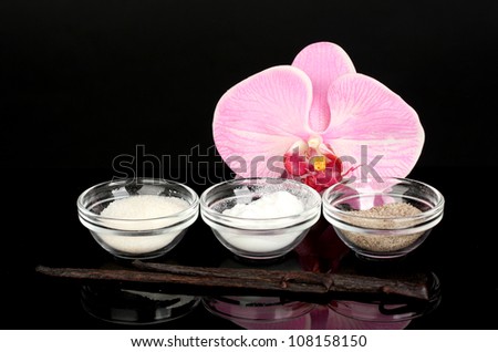 Vanilla pods, vanilla, vanilla sugar and vanilla essence isolated on black