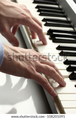 hands of man playing piano