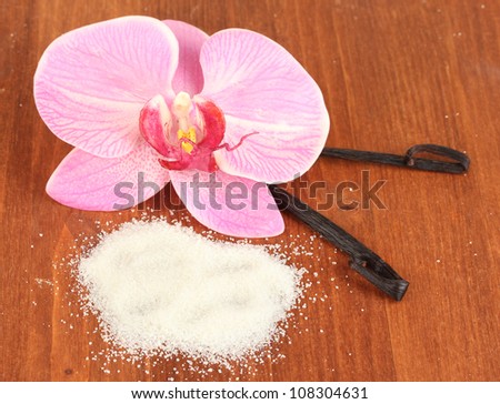 Vanilla pods and vanilla sugar on wooden background close-up
