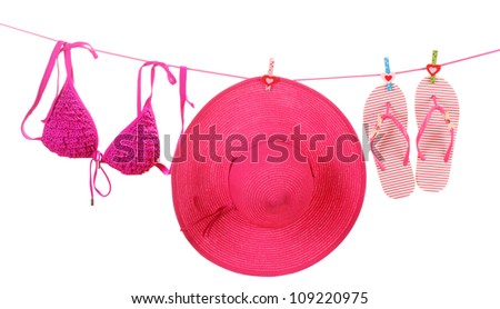 Women\'s bra swimsuit, hat and flip-flops hanging on a rope on white background