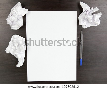 empty paper, crumpled paper and pen on wooden table