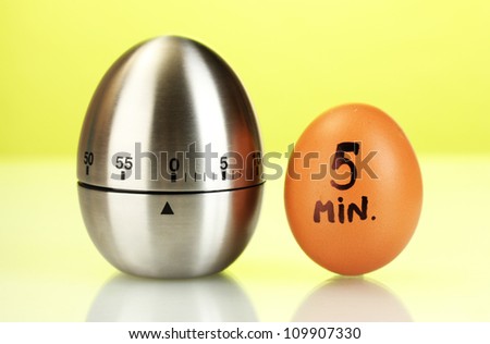 egg timer and egg  on green background