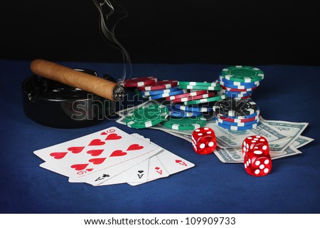 four of a kind on a blue poker table with dollars, playing cards and poker chips
