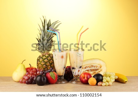 Milk shakes with fruit on yellow background close-up