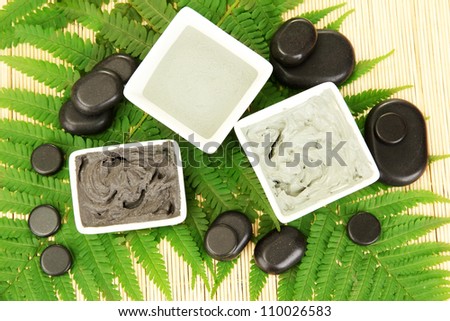 cosmetic clay for spa treatments on straw background close-up